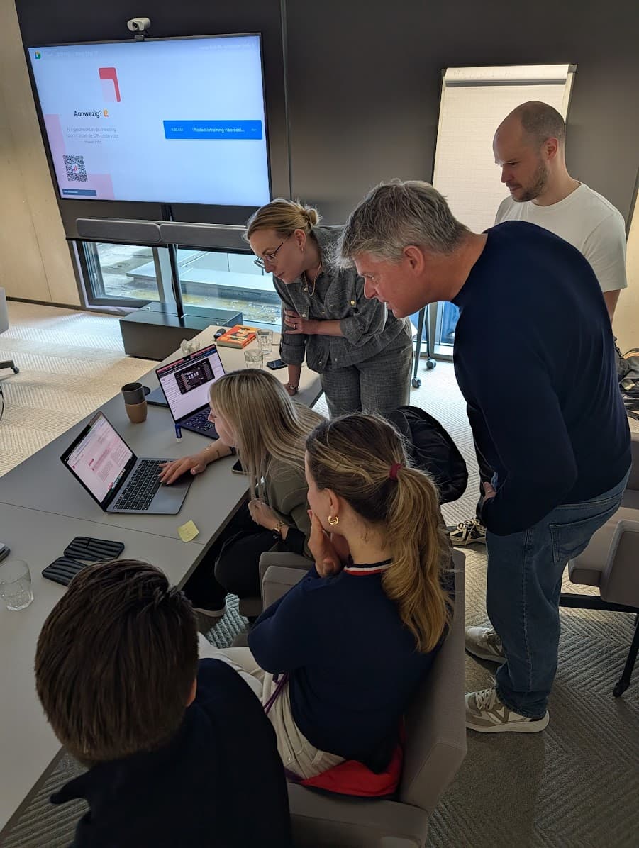 Deelnemers kijken samen mee op een laptop tijdens de masterclass